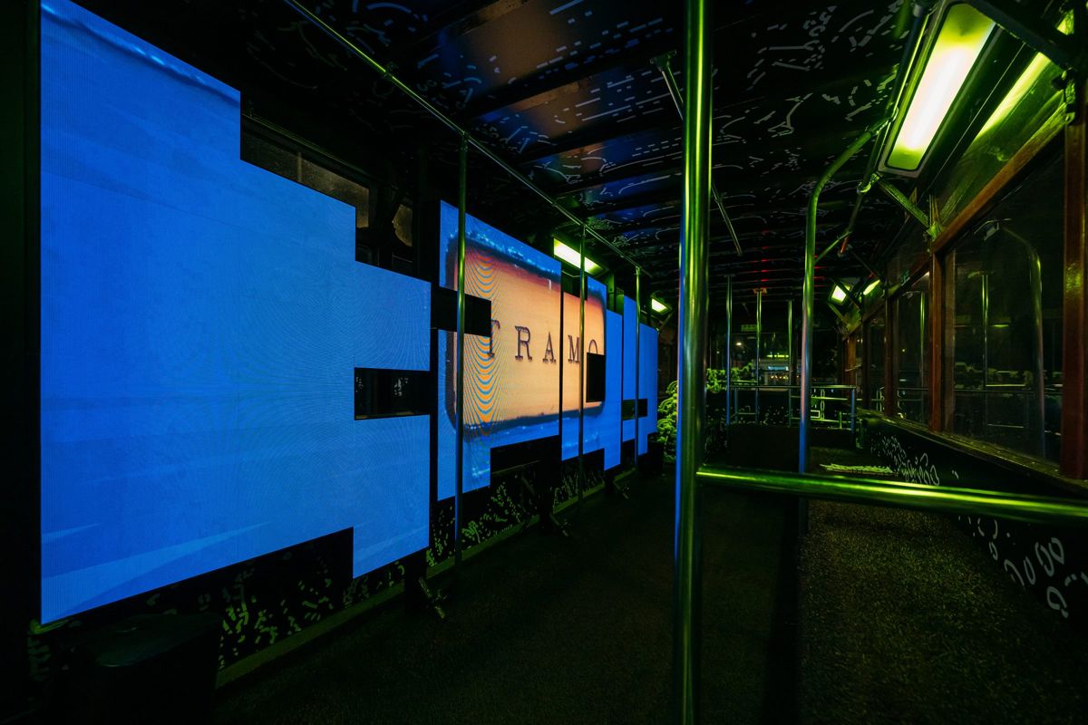 The upper deck at night with blue screens spelling TRAM0.