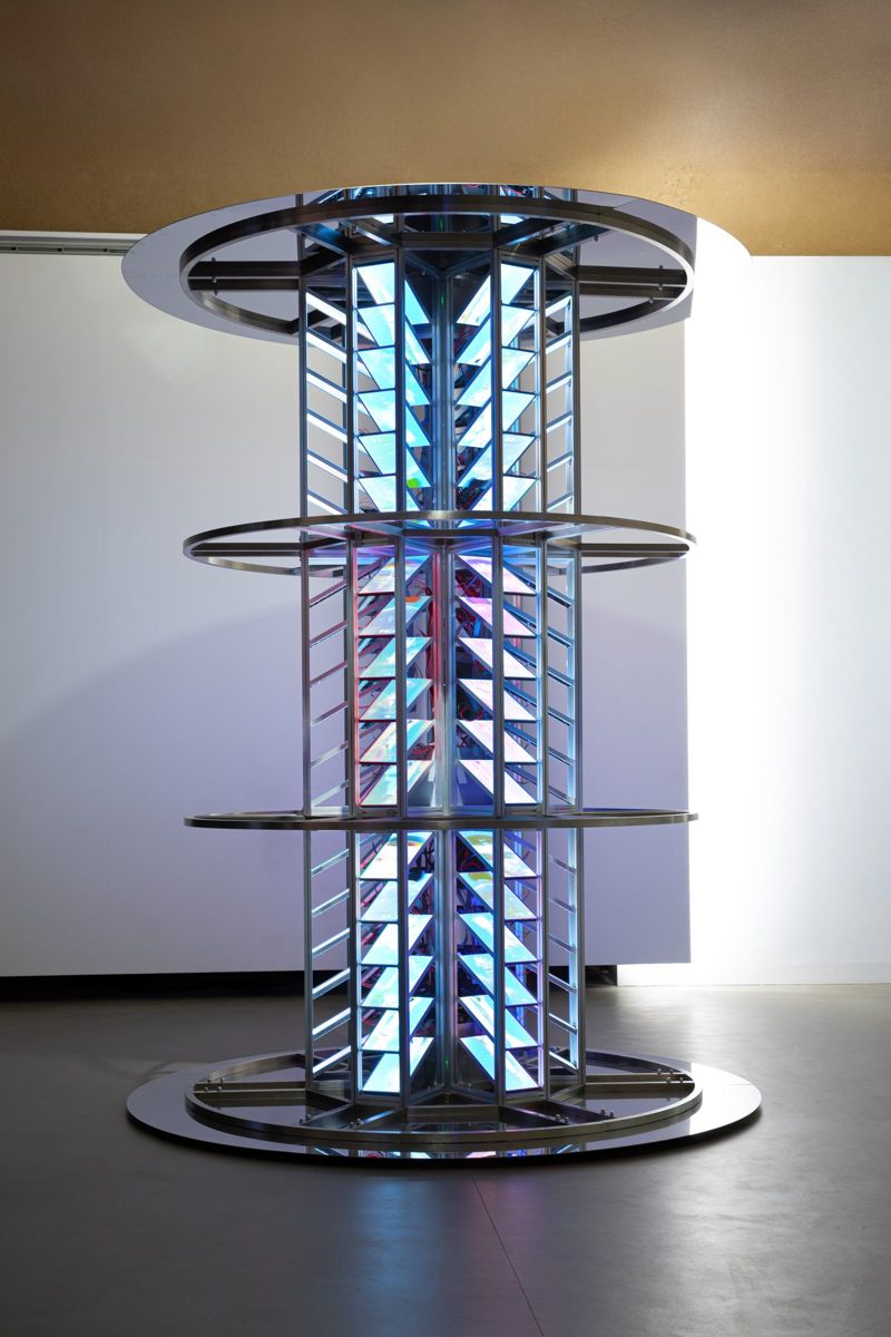 The full tower, ringed with steel bands, glowing blue and white.