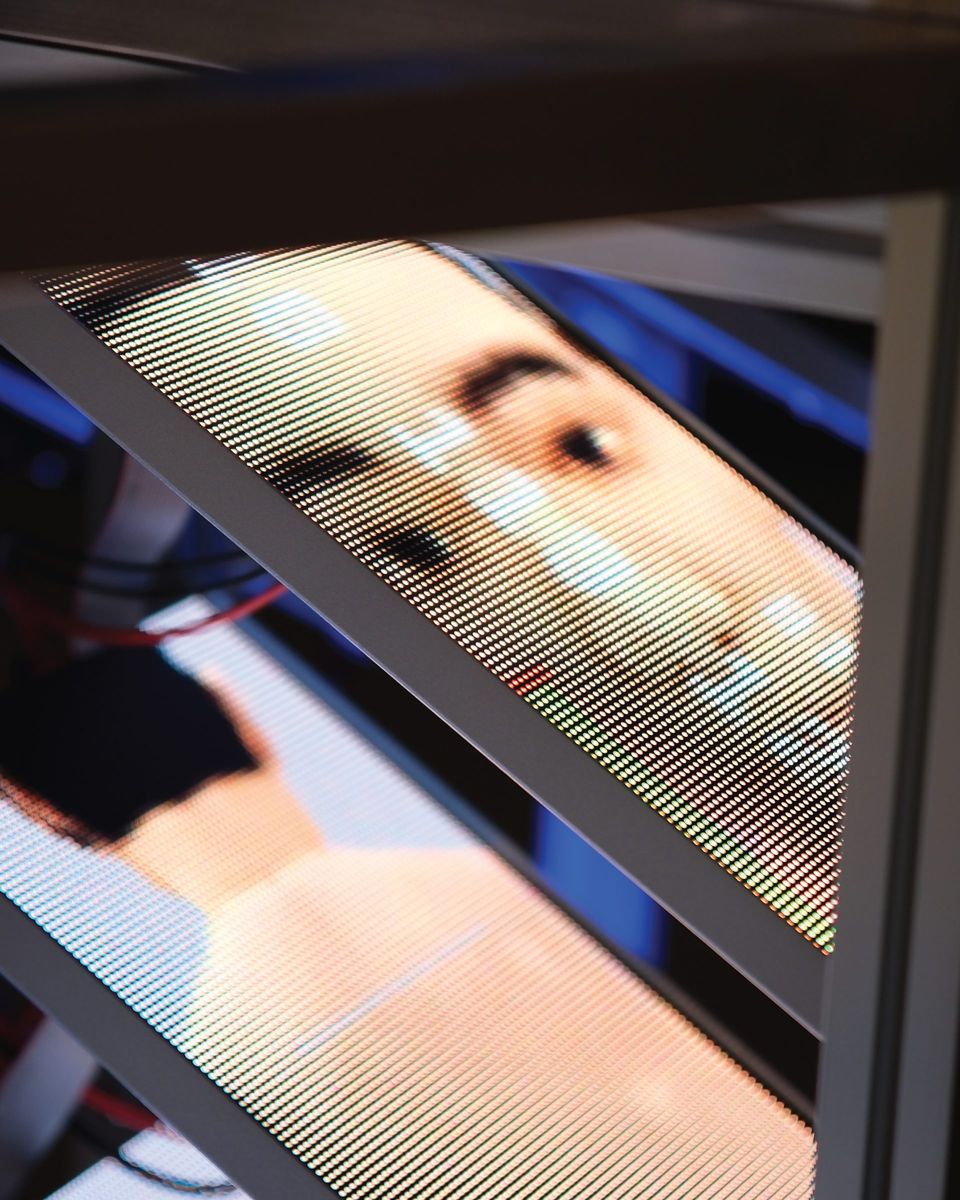 Close-up of a screen showing a mannequin face through LED lines.